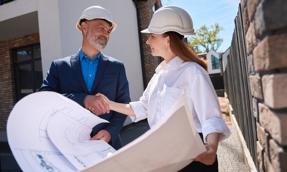 Smiling architect and general contractor shaking hands